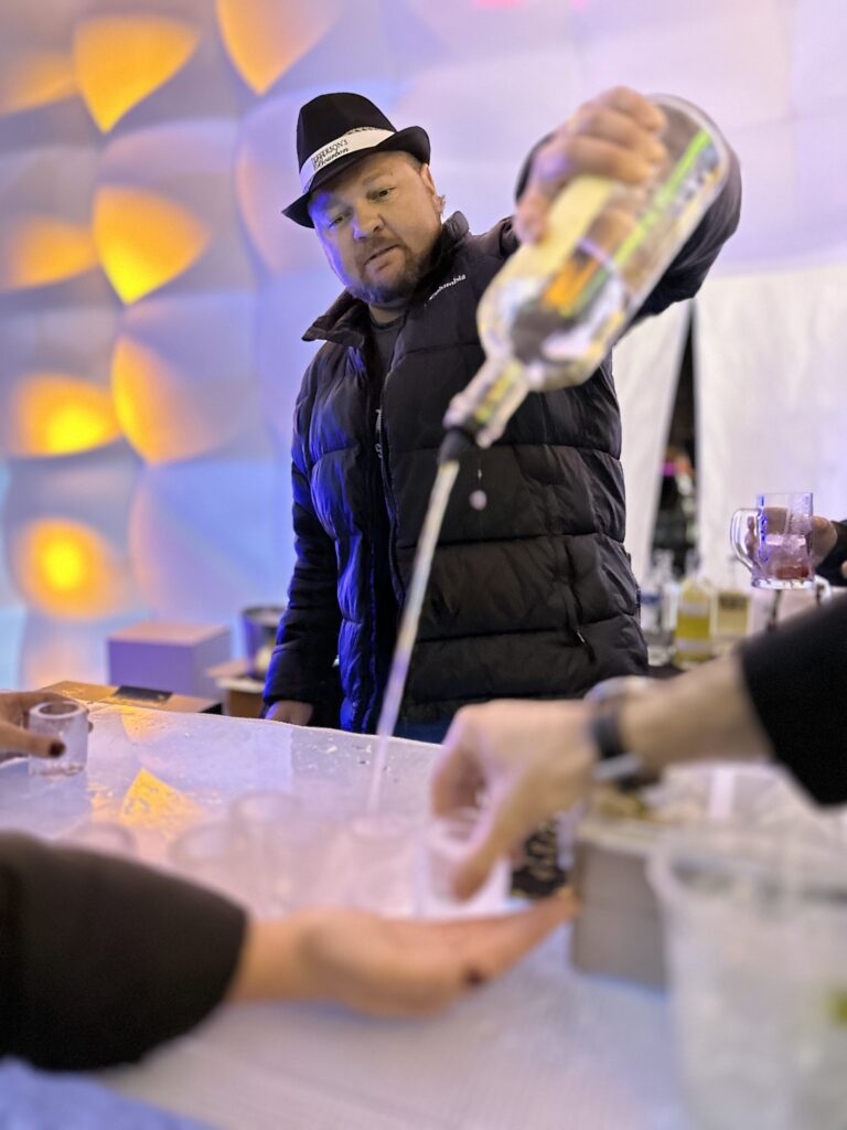 man pouring shots at an ice bar